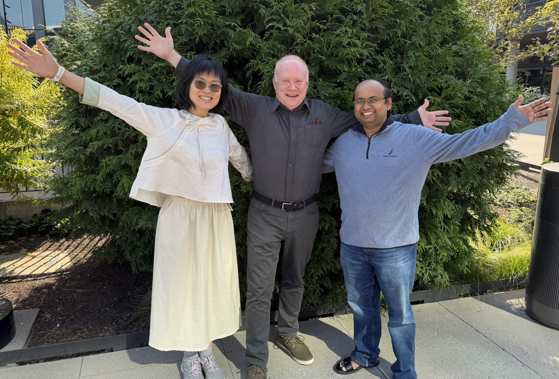 All three authors together with raised arms in a joyful group photo